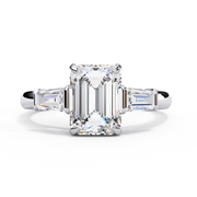 Diamond ring with emerald-cut center stone on a white background